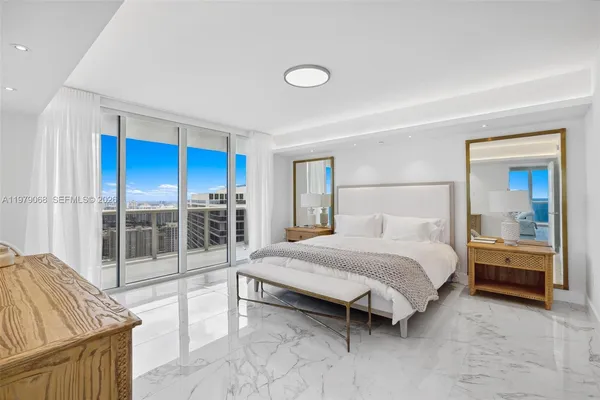 a bedroom with a balcony a bed and a dresser next to a window