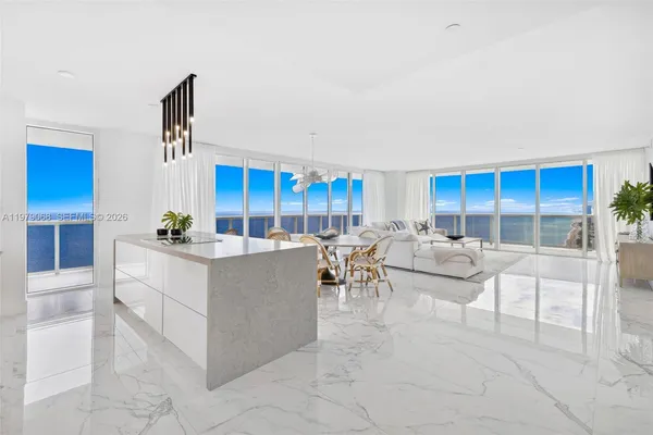 a large white kitchen with a large window and stainless steel appliances