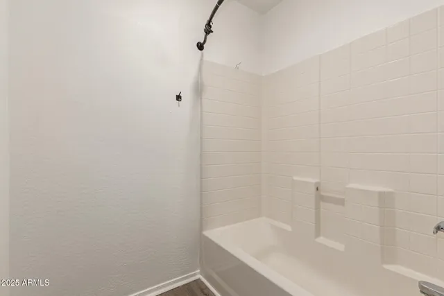 a bathroom with a white bath tub and a shower