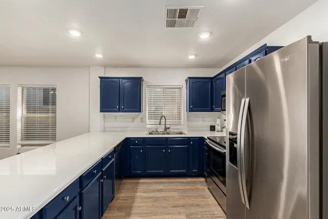 a kitchen with stainless steel appliances granite countertop a refrigerator and a sink