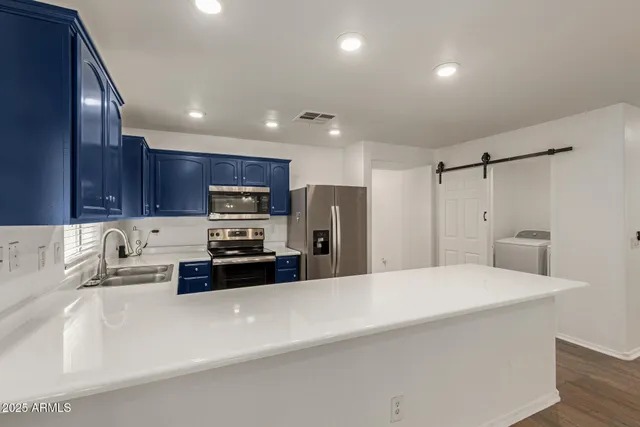 a kitchen with stainless steel appliances a refrigerator sink and microwave