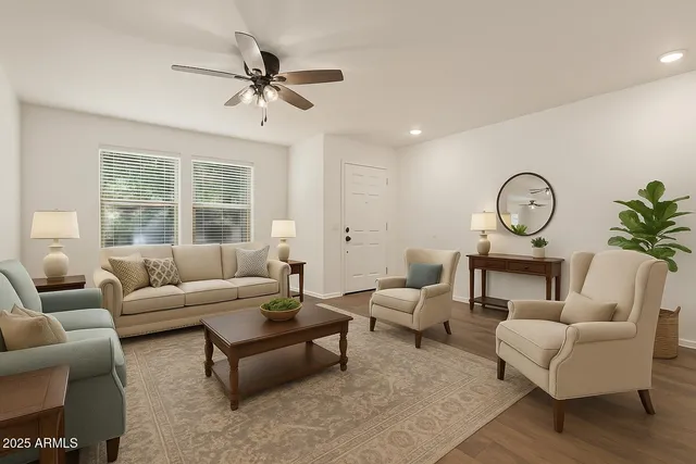 a living room with furniture a clock potted plant and a large window
