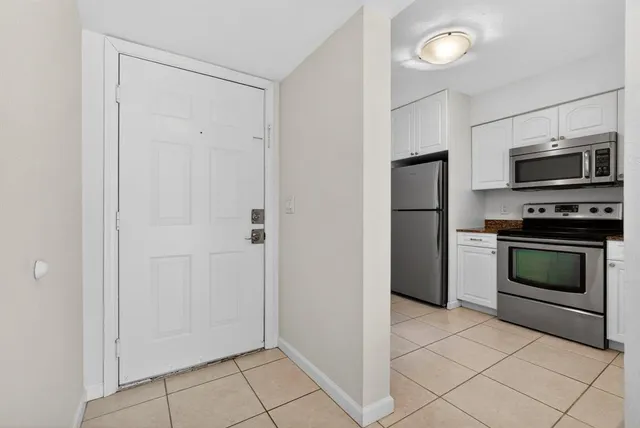 a kitchen with a refrigerator and a stove top oven