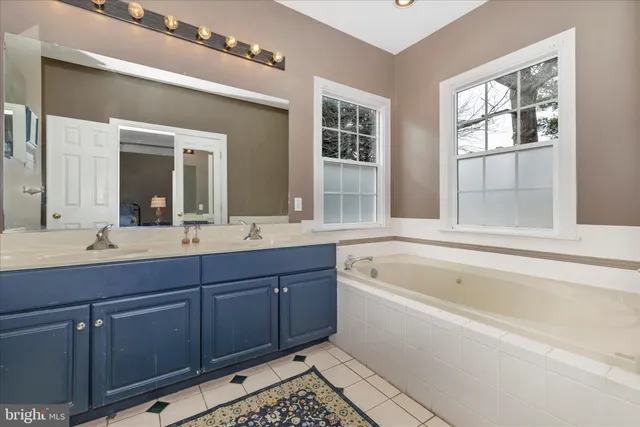 a bathroom with a sink a mirror and a window