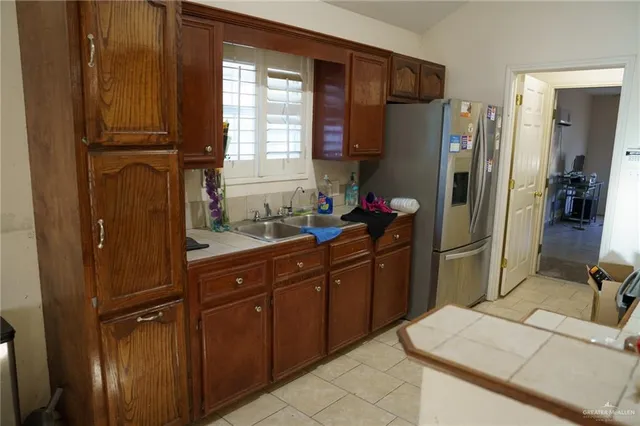 a kitchen with stainless steel appliances granite countertop a refrigerator and a sink