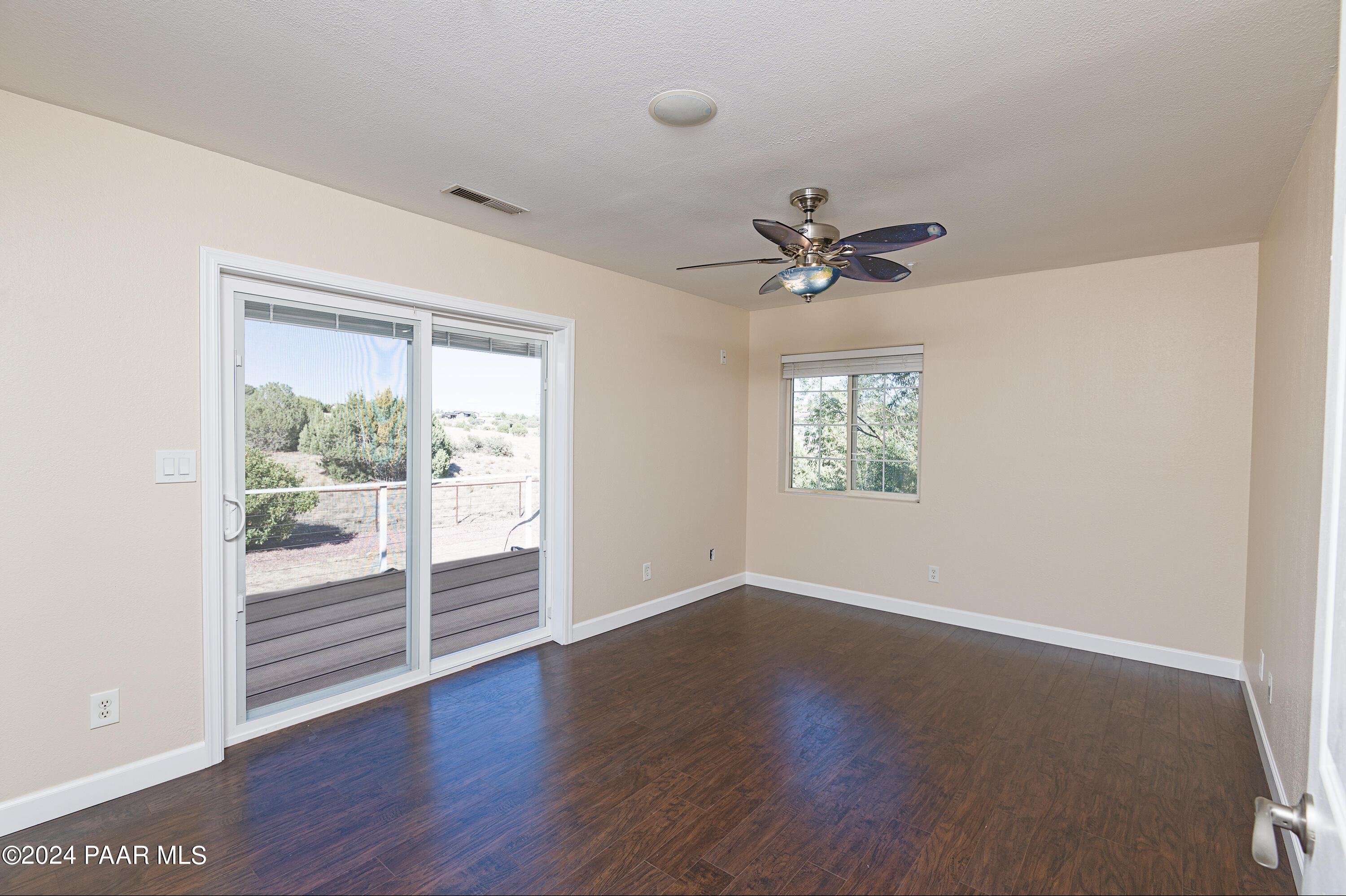 4860 West Stazenski Road Prescott, AZ 86305 - Photo 36 of 67 an empty room with wooden floor and a ceiling fan