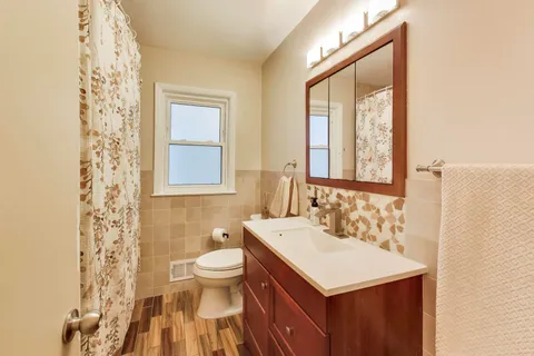 a bathroom with a sink toilet and mirror