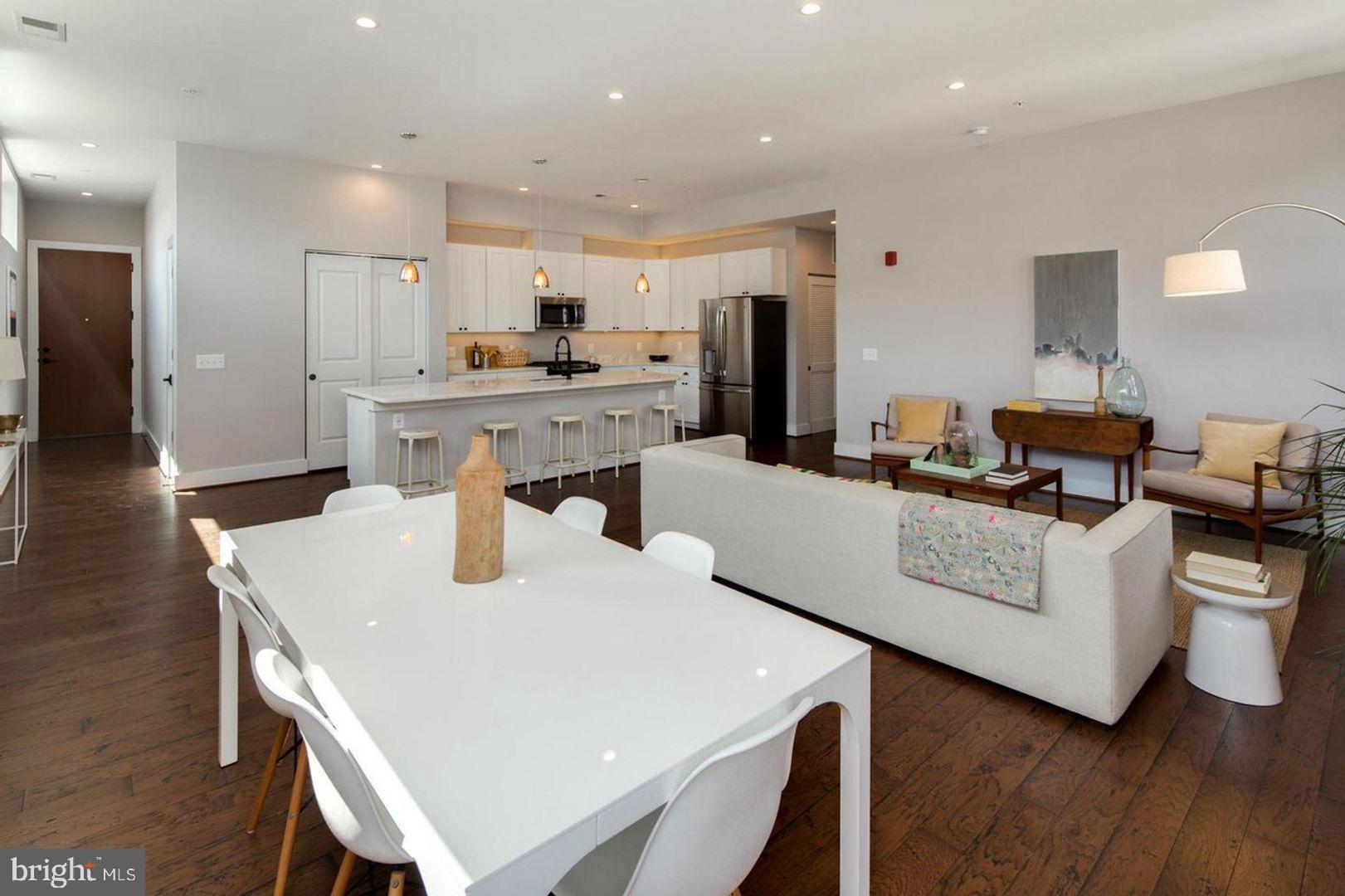 3542 Warder Street Northwest, Unit 204 Washington, DC 20010 - Photo 12 of 29 a living room with stainless steel appliances kitchen island a table and chairs
