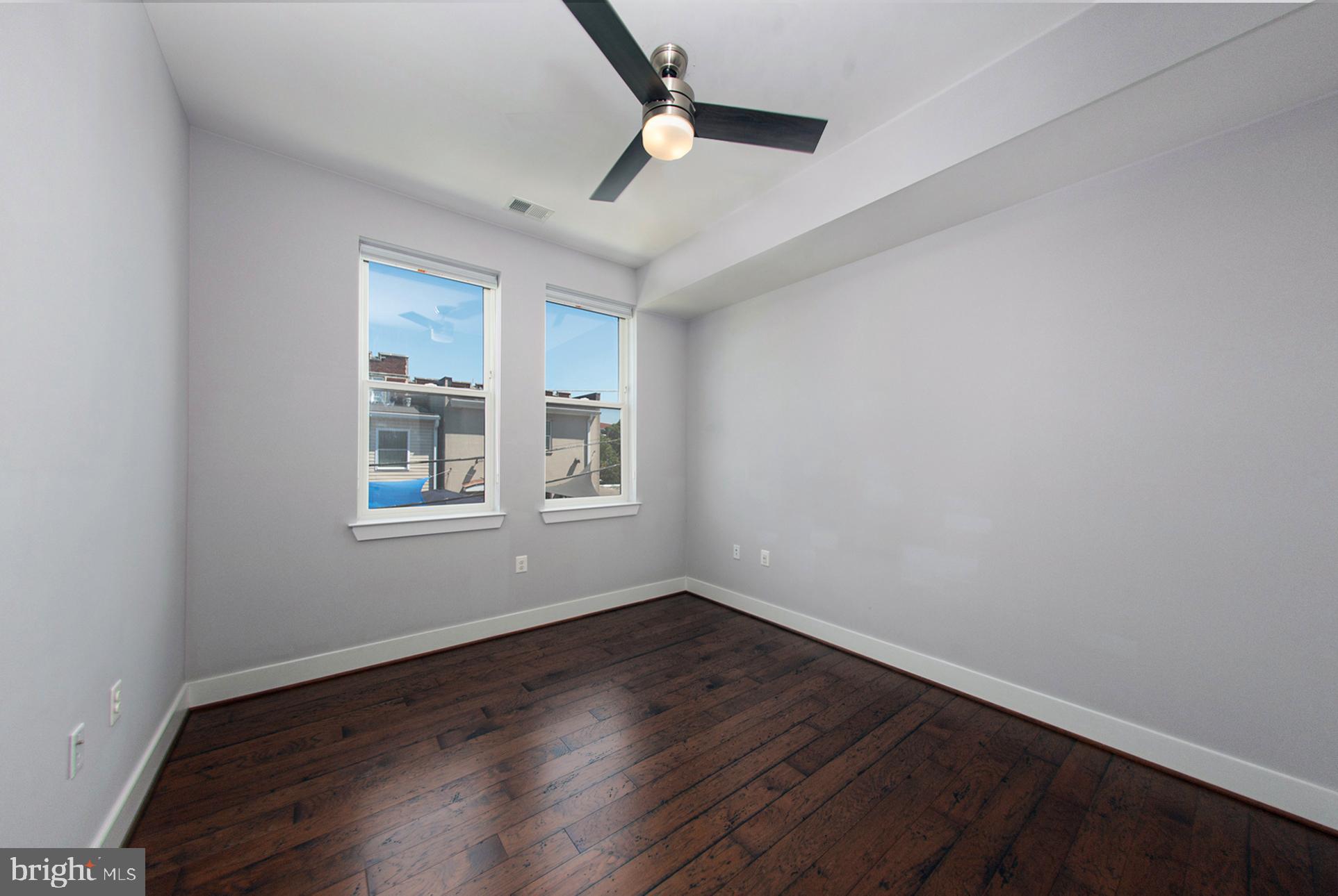 3542 Warder Street Northwest, Unit 204 Washington, DC 20010 - Photo 21 of 29 an empty room with wooden floor and windows