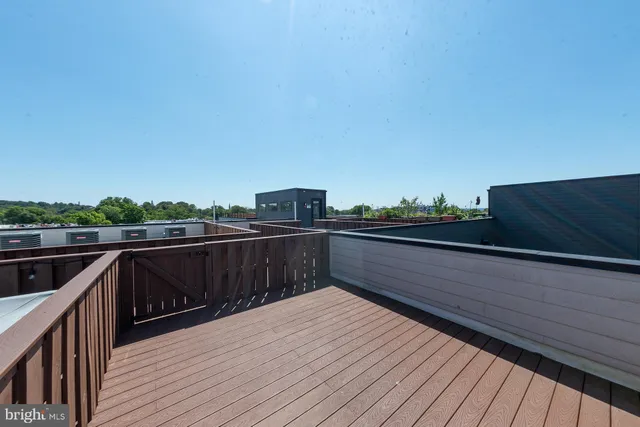 a view of roof deck with wooden floor and fence