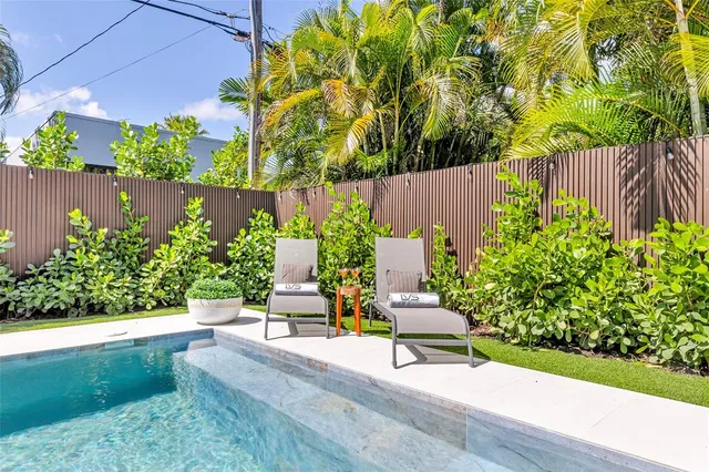 a living room with patio furniture and a large window