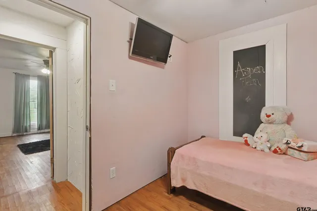 a bedroom with a bed and wooden floor