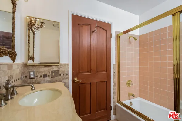 a bathroom with a granite countertop sink and a mirror