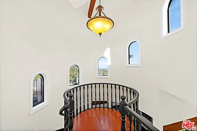 a view of staircase with a potted plant on a table and a painting