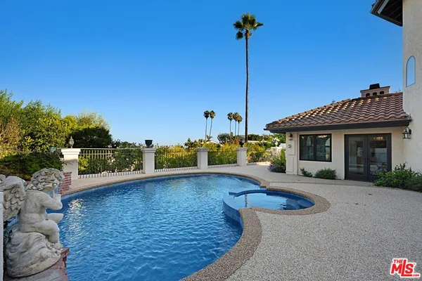 a view of a house with a swimming pool and sitting area
