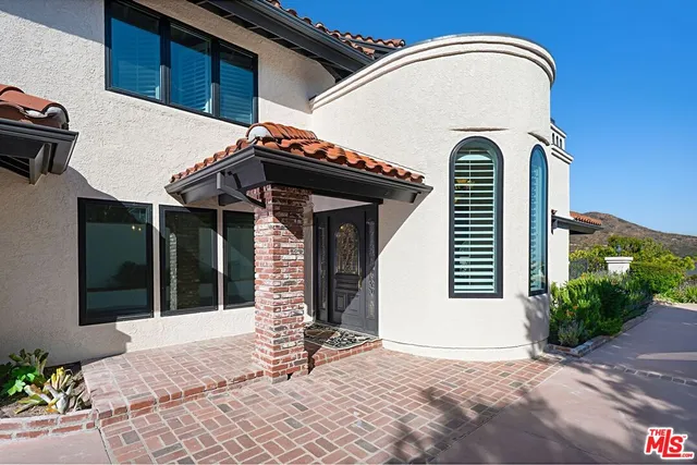 a view of a house with a door and a car parked in front of it