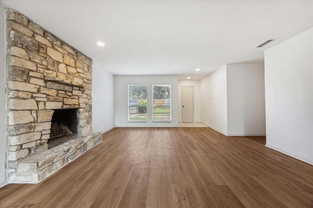 Unfurnished living room with wood finished floors and a fireplace