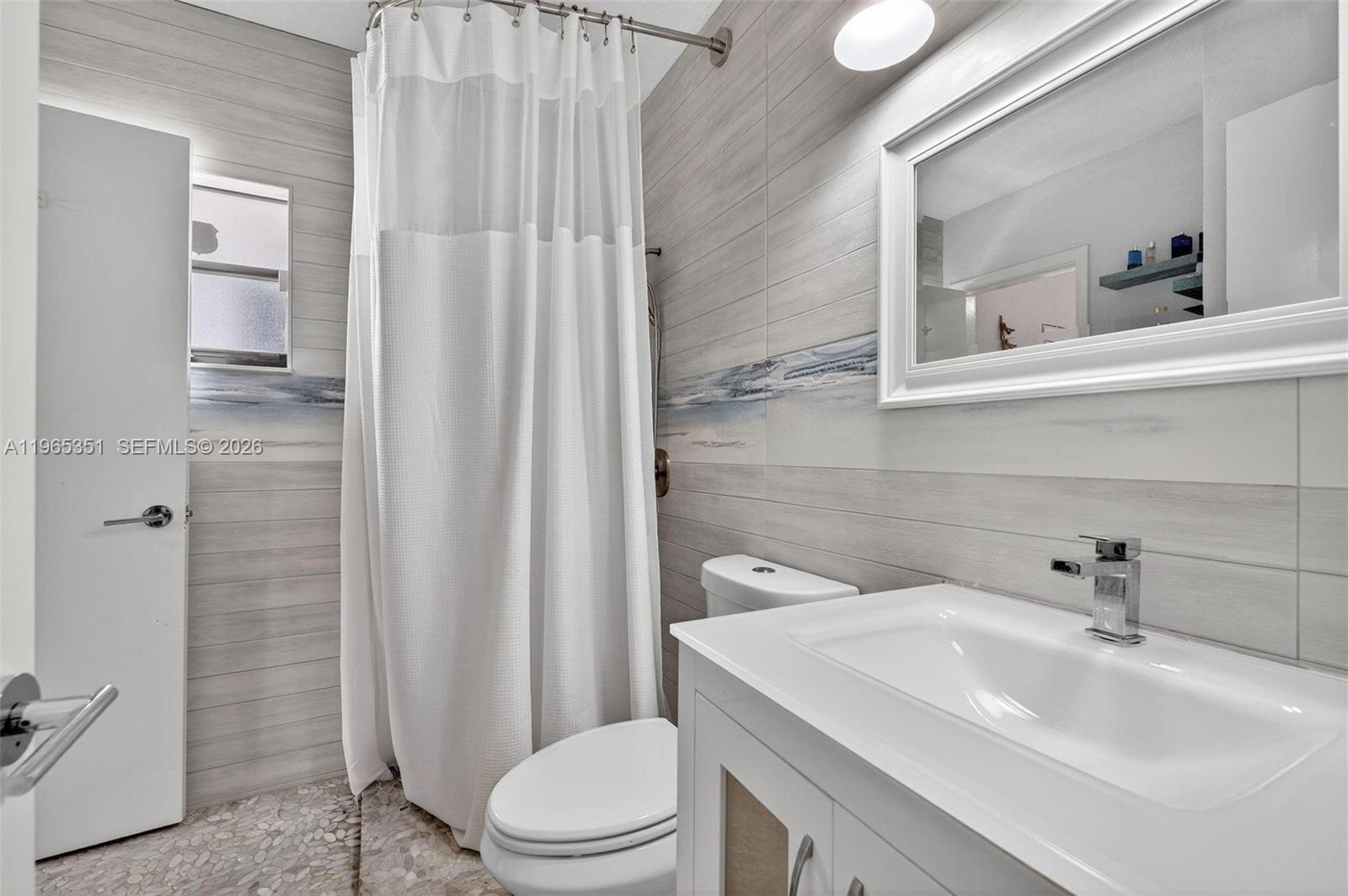 317 South Riverside Drive Pompano Beach, FL 33062 - Photo 17 of 25 a bathroom with a sink a toilet and shower