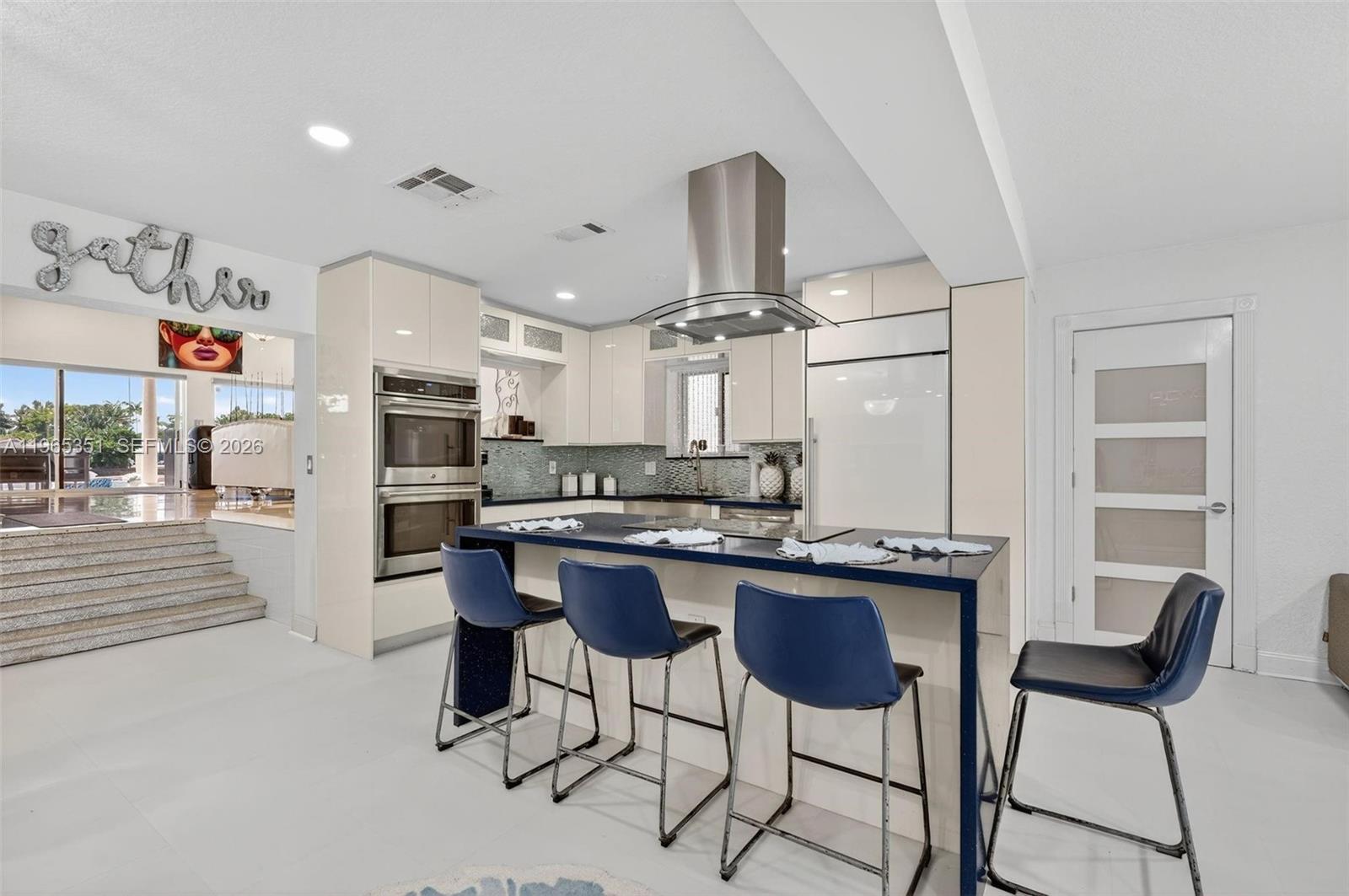 317 South Riverside Drive Pompano Beach, FL 33062 - Photo 4 of 25 a kitchen with stainless steel appliances a table chairs and a refrigerator
