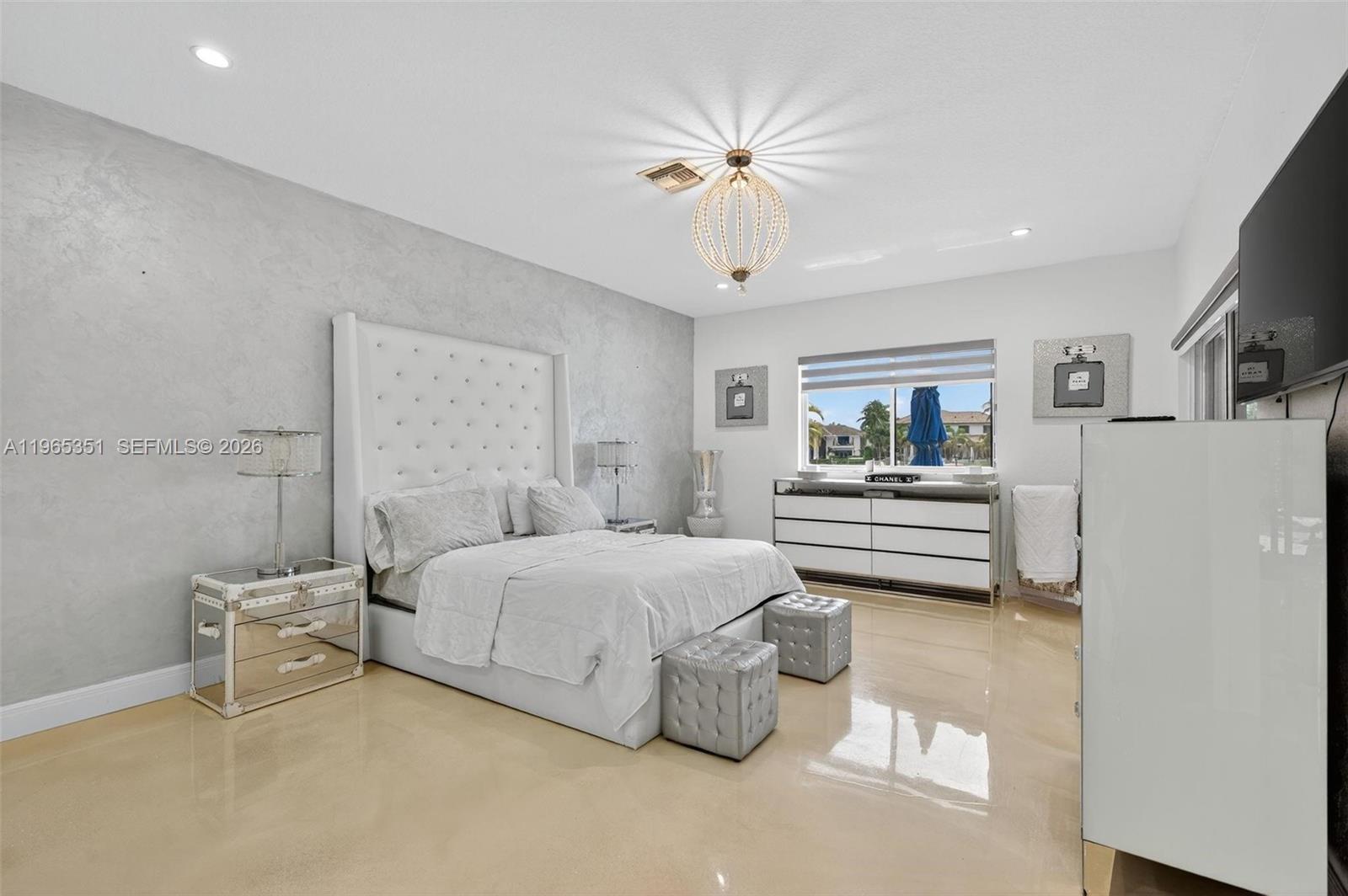 317 South Riverside Drive Pompano Beach, FL 33062 - Photo 10 of 25 a bedroom with a bed and a chandelier