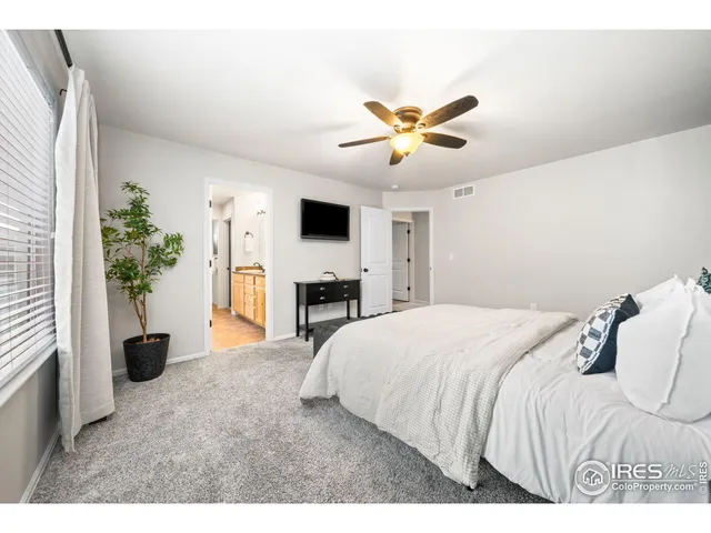 a spacious bedroom with a bed and a chandelier
