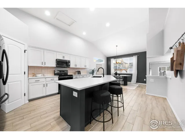 a kitchen with a sink a refrigerator and wooden floor