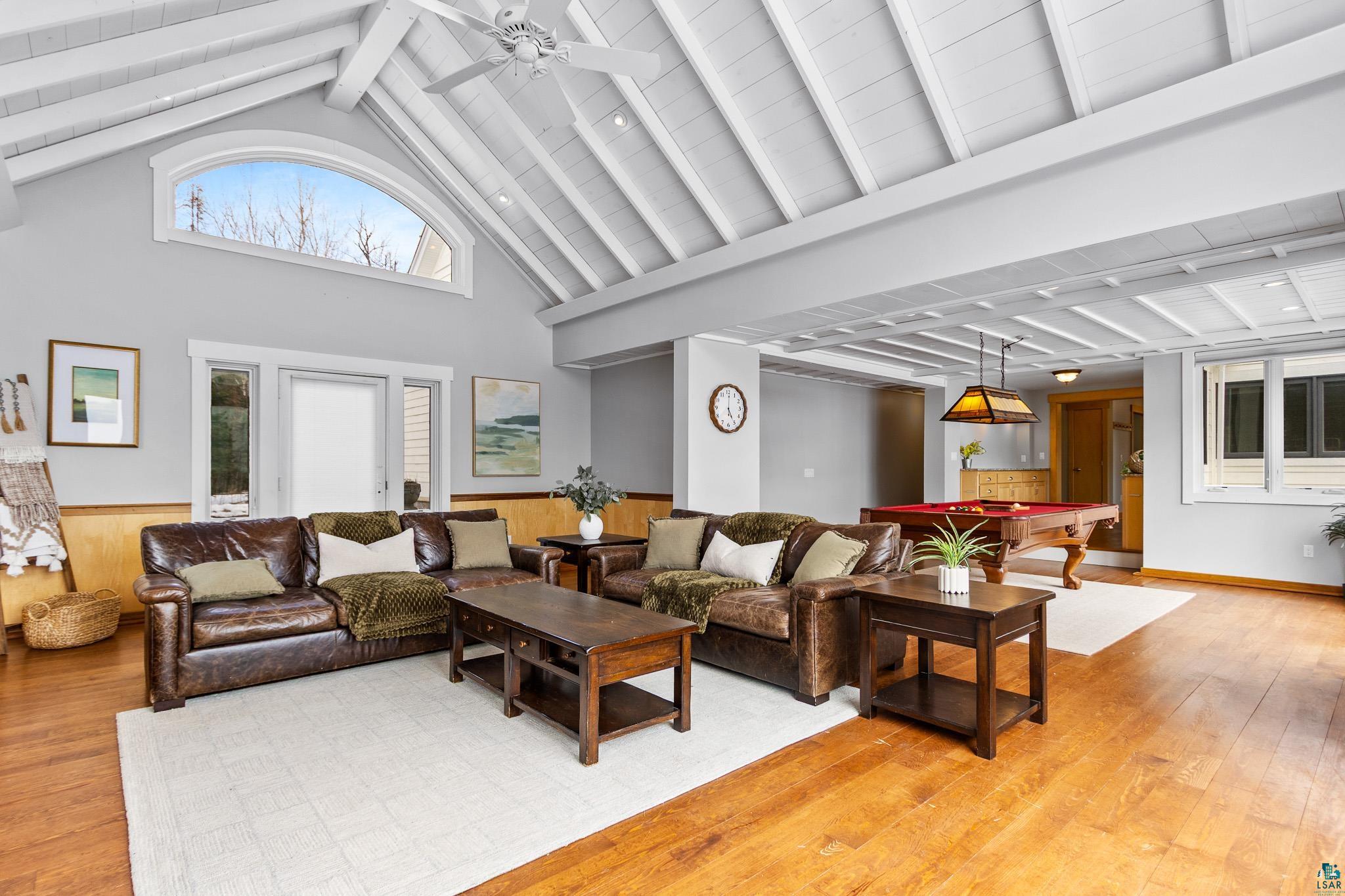 5163 Greenwood Road Duluth, MN 55804 - Photo 7 of 47 Vaulted ceiling with exposed beams, wood-finish flooring, and a large arched window