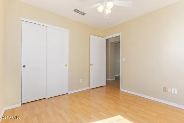 a view of an empty room with a chandelier fan