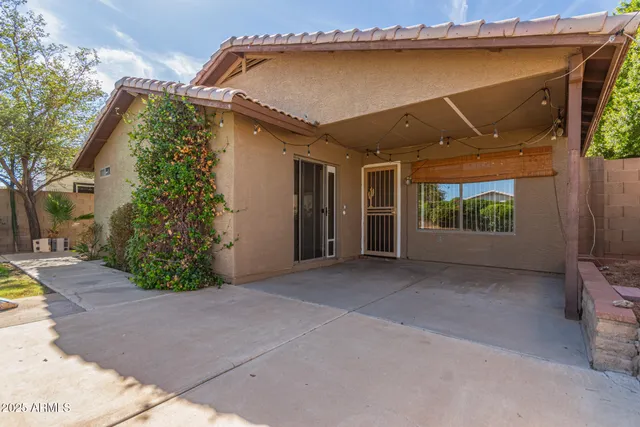 a view of a house with a yard and potted plants