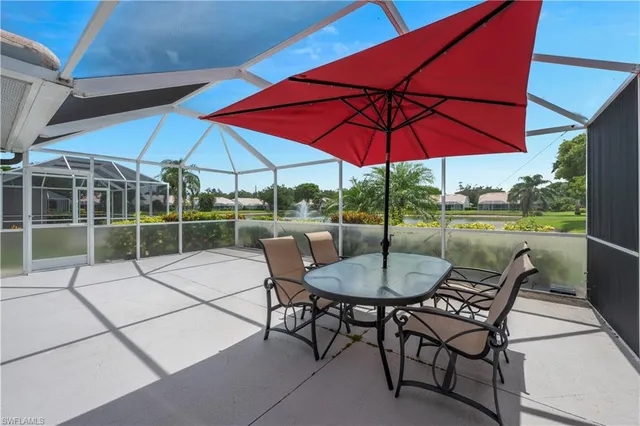 a patio with a table and chairs under an umbrella