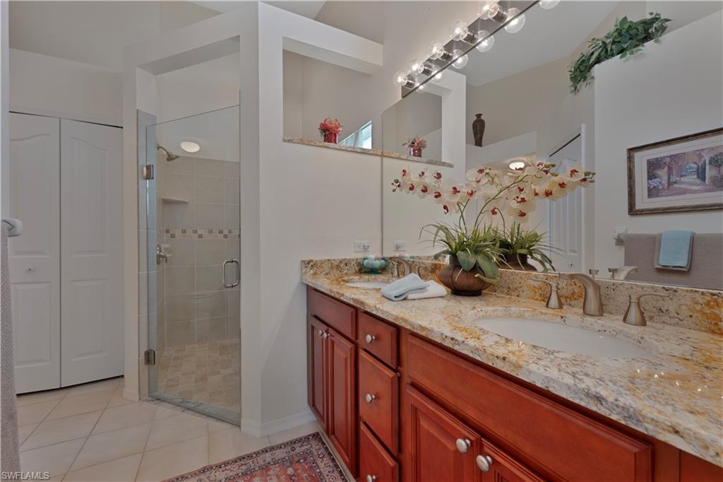 2166 Stacil Circle Naples, FL 34109 - Photo 14 of 18 a bathroom with a granite countertop sink a large mirror and a shower