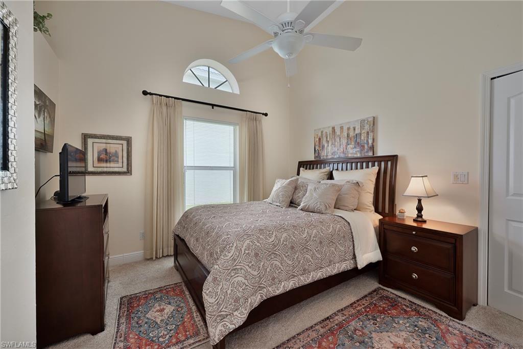2166 Stacil Circle Naples, FL 34109 - Photo 16 of 18 a bedroom with a bed and a chandelier