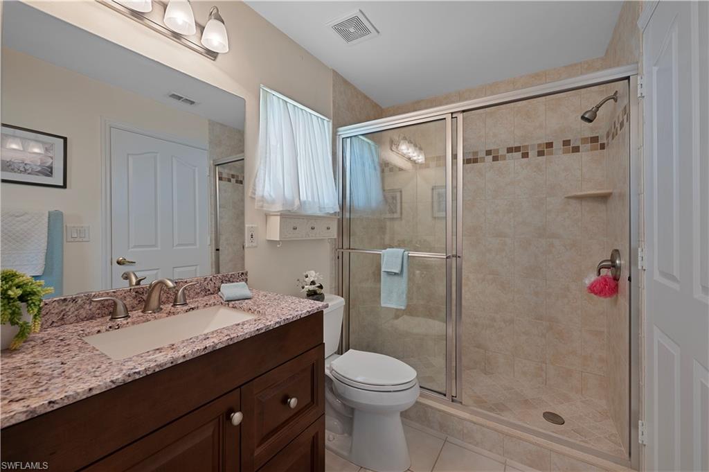 2166 Stacil Circle Naples, FL 34109 - Photo 17 of 18 a bathroom with a granite countertop sink toilet and shower