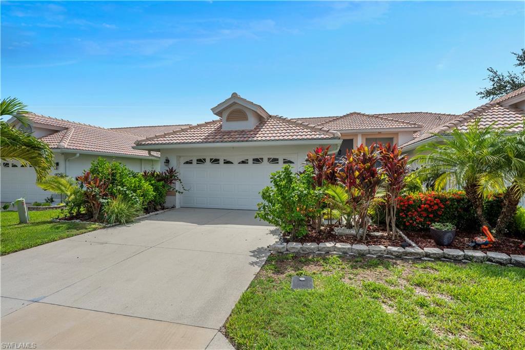 2166 Stacil Circle Naples, FL 34109 - Photo 2 of 18 a front view of a house with a yard and large trees