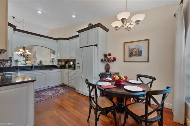a view of a dining room with furniture a chandelier and wooden floor