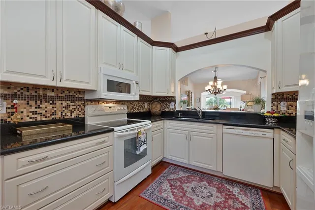 a kitchen with stainless steel appliances granite countertop a sink a stove and cabinets
