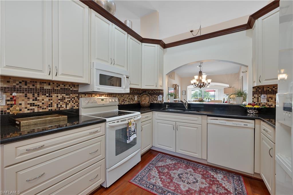 2166 Stacil Circle Naples, FL 34109 - Photo 6 of 18 a kitchen with stainless steel appliances granite countertop a sink a stove and cabinets