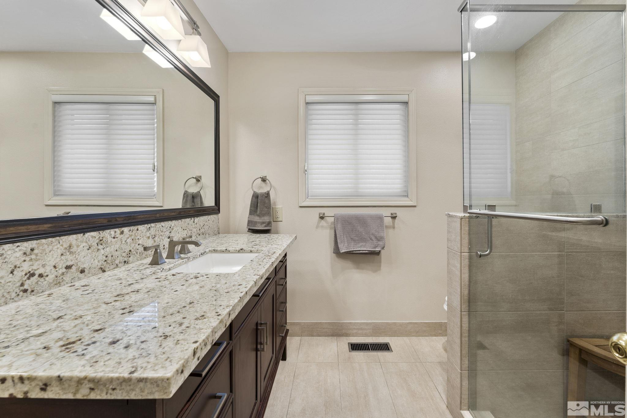 2650 Spinnaker Drive Reno, NV 89519 - Photo 27 of 40 a bathroom with a granite countertop sink a mirror and a shower