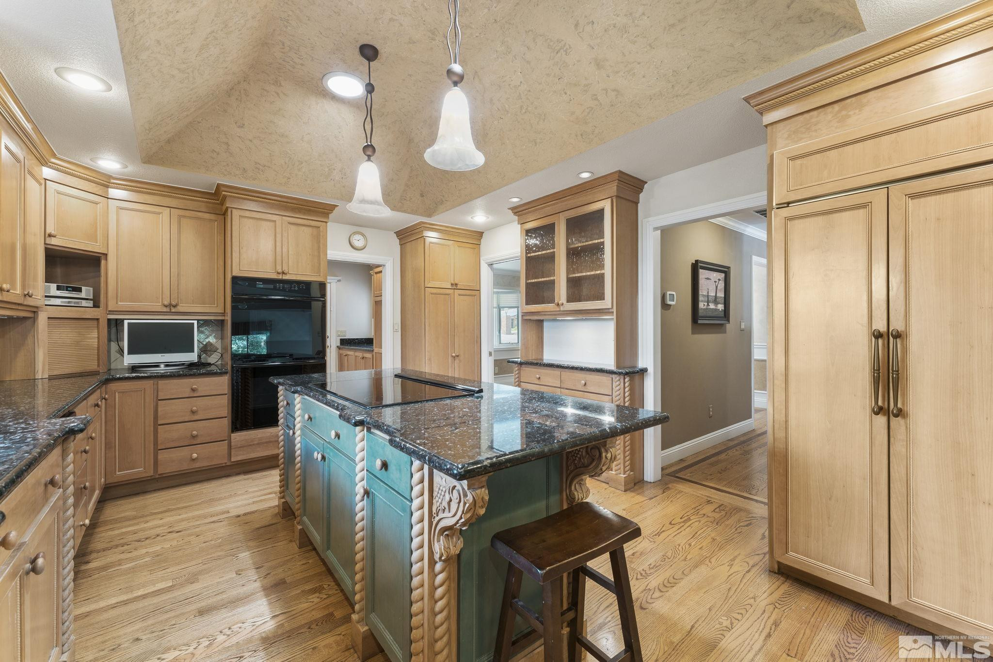 2650 Spinnaker Drive Reno, NV 89519 - Photo 9 of 40 a kitchen with stainless steel appliances kitchen island granite countertop a stove top oven a sink dishwasher a dining table and chairs with wooden floor