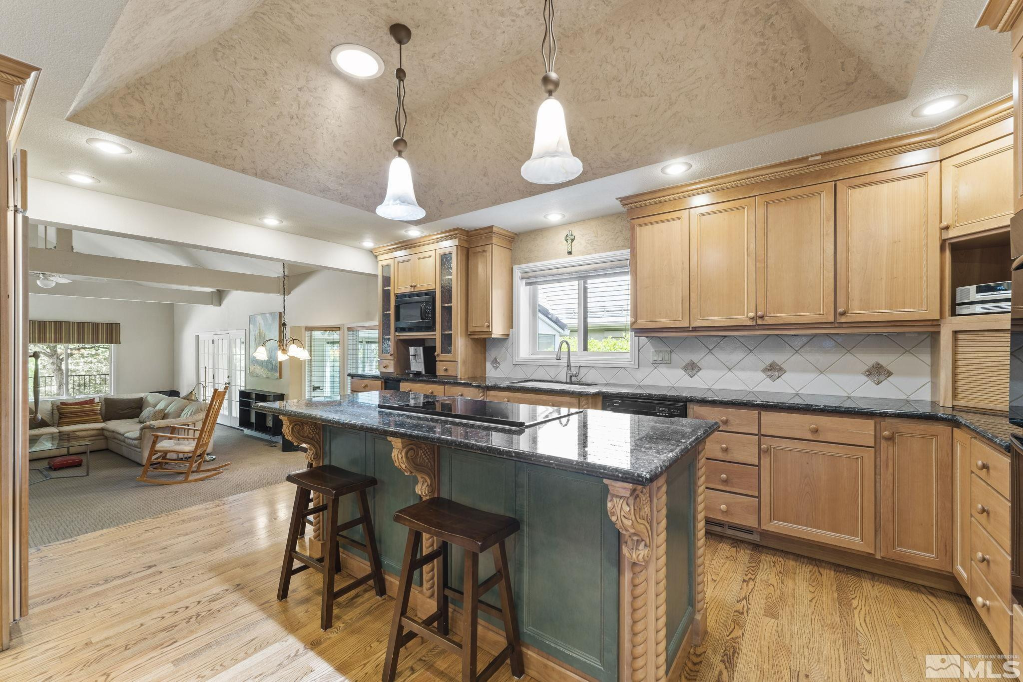 2650 Spinnaker Drive Reno, NV 89519 - Photo 10 of 40 a kitchen with stainless steel appliances granite countertop a table chairs sink and cabinets