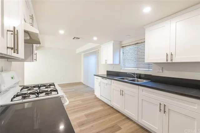 a kitchen with granite countertop a sink and a stove