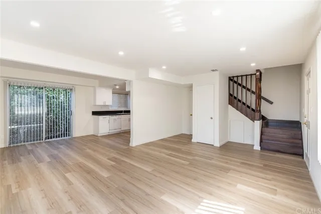 a view of empty room with wooden floor and stairs