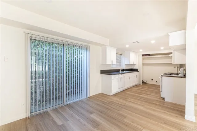 a kitchen with a refrigerator and white cabinets