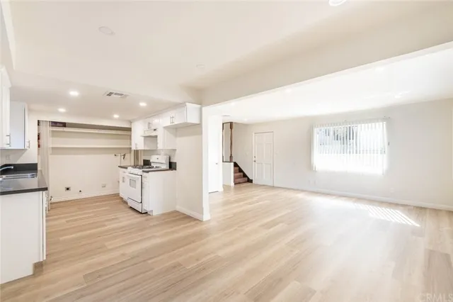 a view of a kitchen with a sink and wooden floor