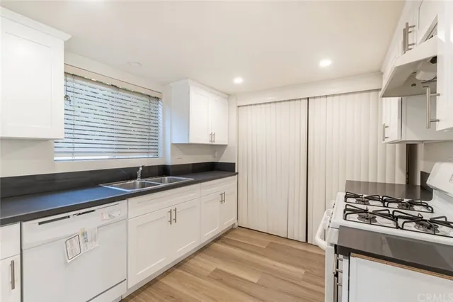 a kitchen with granite countertop a sink stove and refrigerator