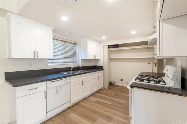 a kitchen with granite countertop a sink stove and cabinets