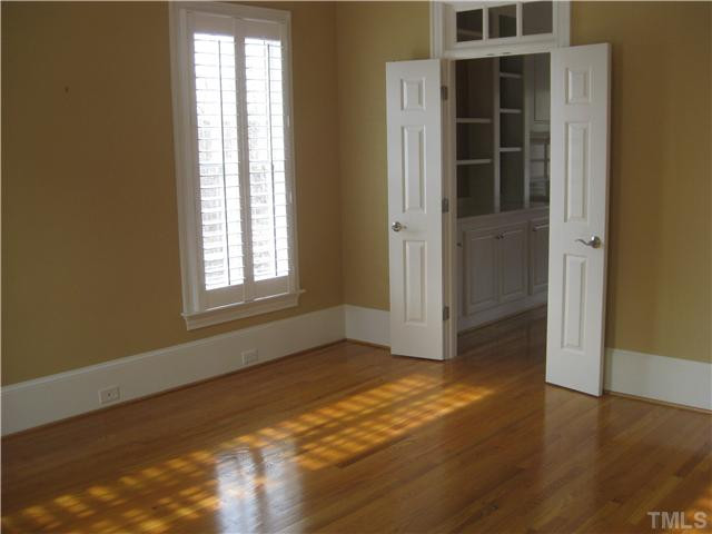 6104 Wilkinsburg Road Raleigh, NC 27612 - Photo 9 of 18 a view of an empty room with wooden floor and a window
