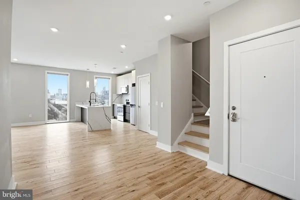 a large kitchen with stainless steel appliances granite countertop a refrigerator oven a sink dishwasher and a refrigerator with wooden floor