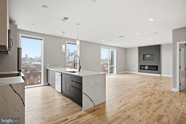 a large kitchen with stainless steel appliances kitchen island granite countertop a refrigerator and a sink