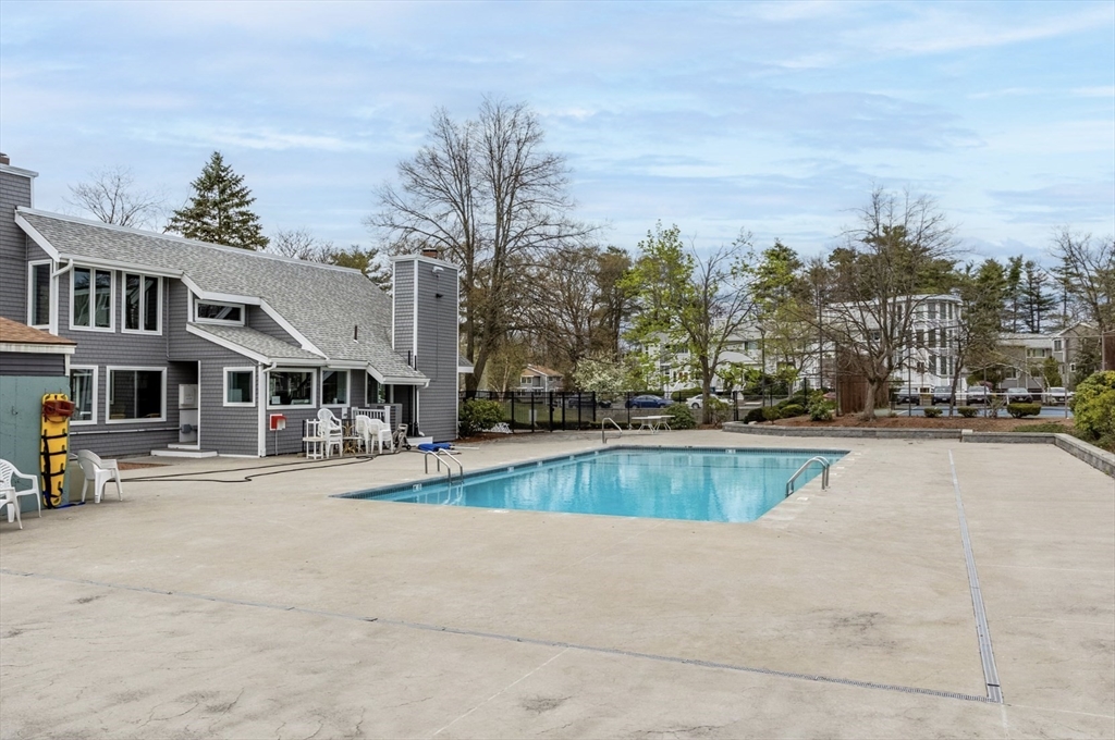 255 North Road, Unit 44 Chelmsford, MA 01824 - Photo 30 of 31 a view of a swimming pool with lawn chairs under an umbrella